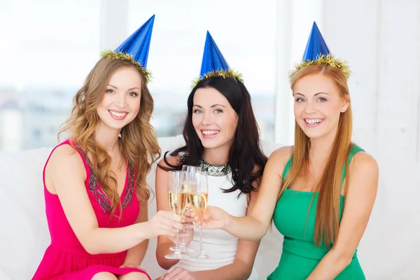 Üç kadın şampanya bardağı ile şapka giymiş — Stok fotoğraf