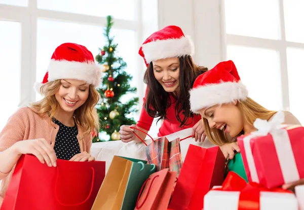 Mulheres em Santa helper chapéus com sacos de compras — Fotografia de Stock