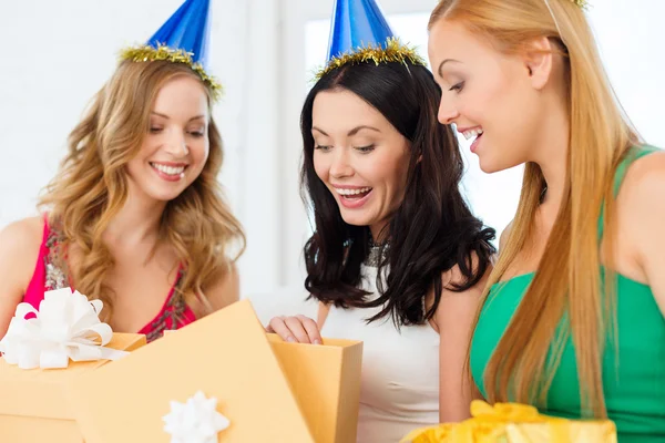 Tres mujeres sonrientes en sombreros azules con cajas de regalo — Foto de Stock