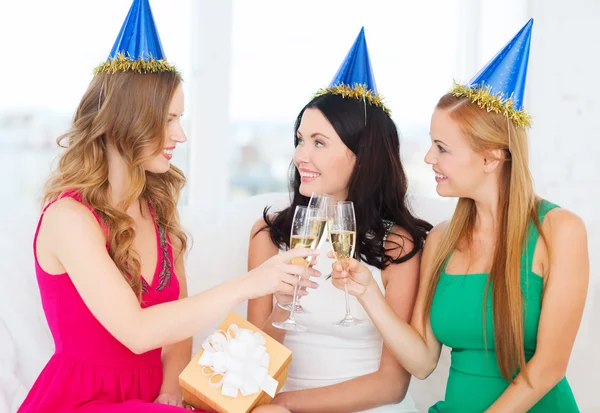 Drie vrouwen dragen hoeden met champagneglazen — Stockfoto