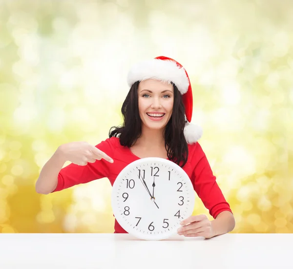 Mujer en sombrero de ayudante de santa con reloj que muestra 12 — Foto de Stock