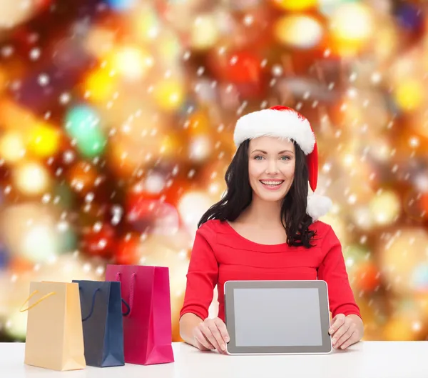 Femme souriante dans le chapeau d'aide de Père Noël avec comprimé pc — Photo