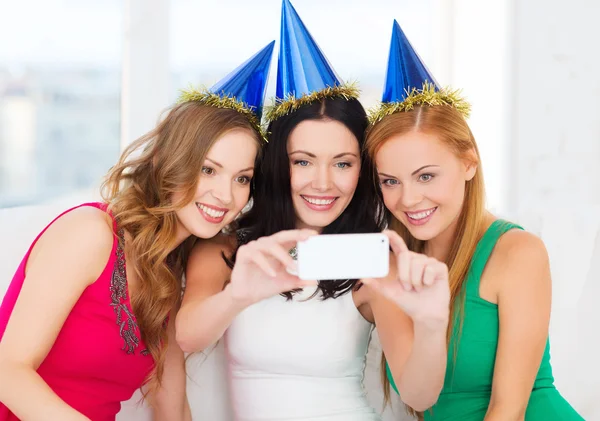 Trois femmes souriantes dans des chapeaux s'amusant avec la caméra — Photo