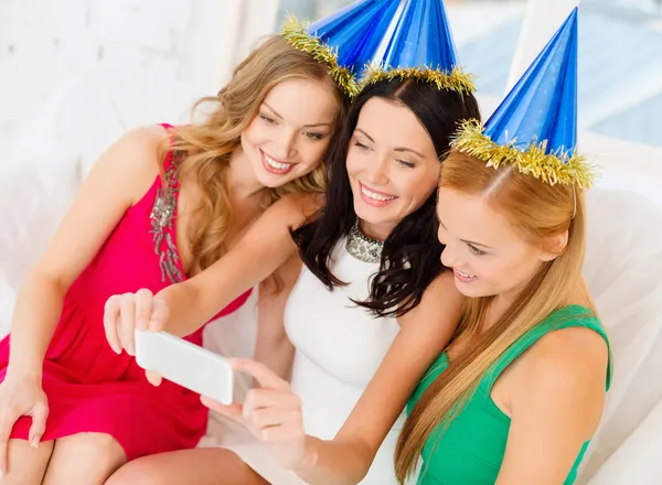 Trois femmes souriantes dans des chapeaux s'amusant avec la caméra — Photo