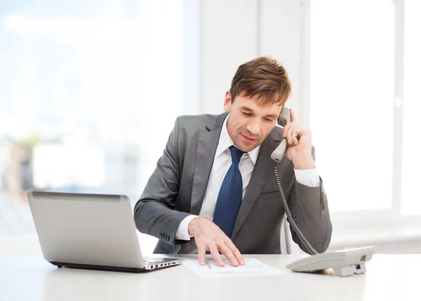 Empresário com computador portátil e telefone — Fotografia de Stock