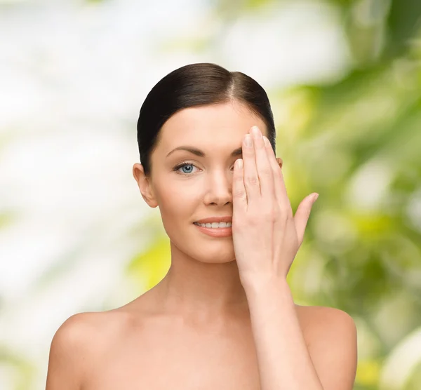 Smiling young woman covering face with hand — Stock Photo, Image