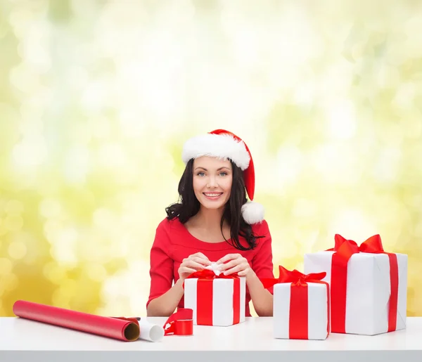 Mujer en sombrero de ayudante de santa con muchas cajas de regalo —  Fotos de Stock