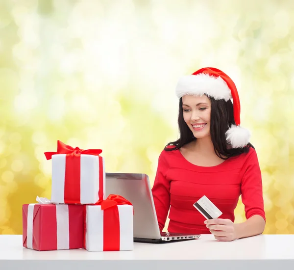 Женщина с подарками, ноутбуком и кредитной картой — стоковое фото