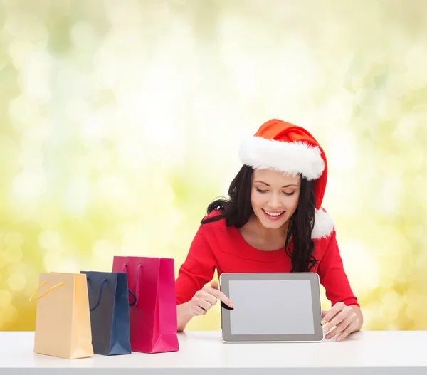 Mujer sonriente en sombrero de ayudante de santa con tableta pc —  Fotos de Stock