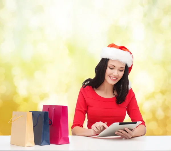 Mulher sorridente com sacos de compras e tablet pc — Fotografia de Stock