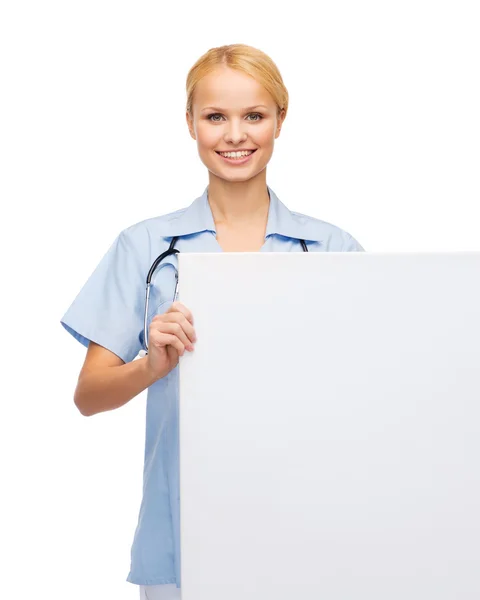 Smiling female doctor or nurse with blank board — Stockfoto