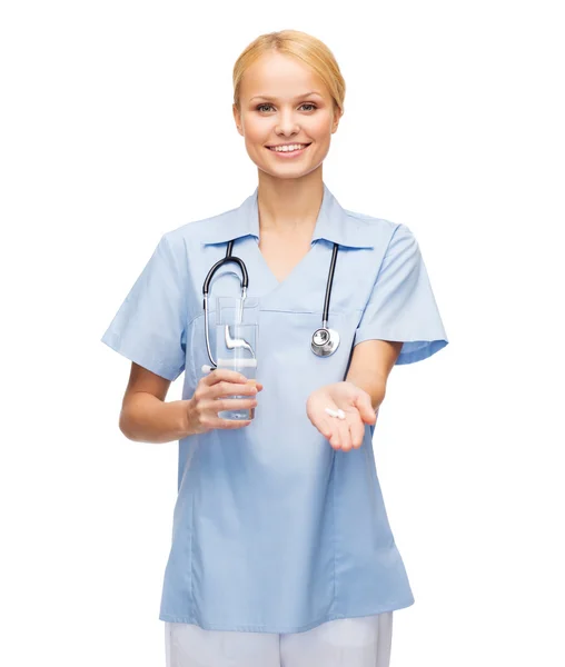 Lächelnder Arzt oder Krankenschwester bietet Pillen und Wasser an — Stockfoto