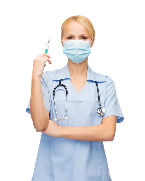 Γυναίκα γιατρό ή νοσοκόμα σε μάσκα κρατώντας τη σύριγγα — Φωτογραφία Αρχείου