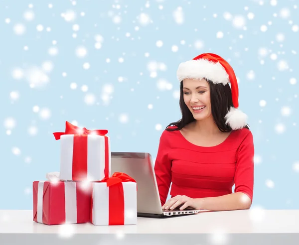 Woman with gift boxes and laptop computer — Stock Photo, Image