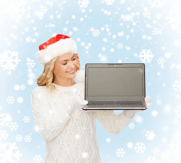 Vrouw in helper kerstmuts met een laptopcomputer — Stockfoto