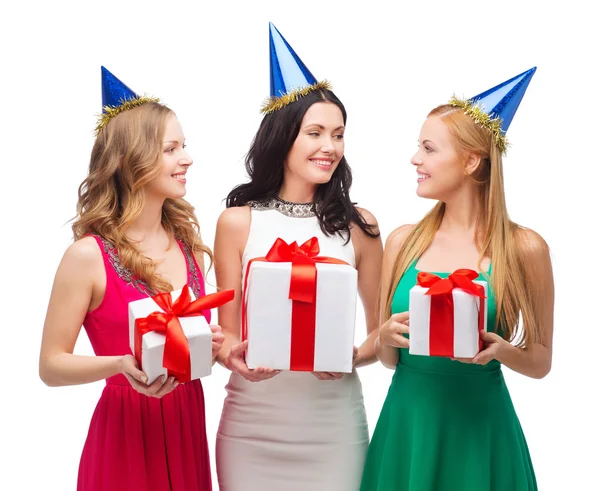 Tres mujeres sonrientes en sombreros azules con cajas de regalo —  Fotos de Stock