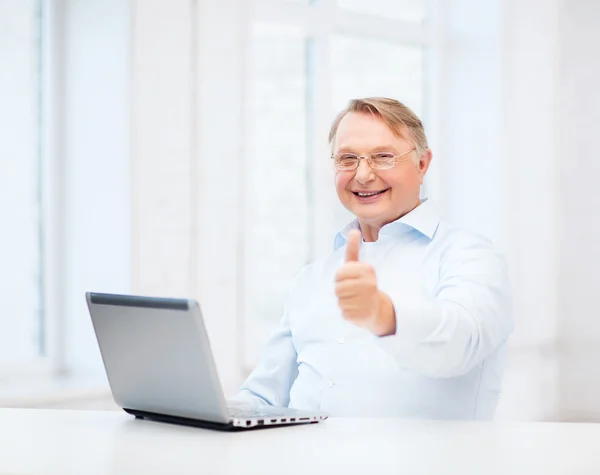 Başparmak gösterilen dizüstü bilgisayar ile yaşlı adam — Stok fotoğraf
