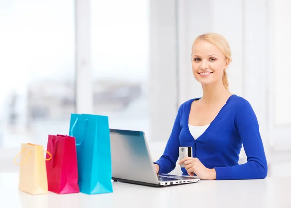 Mulher com sacos de compras, laptop e cartão de crédito — Fotografia de Stock