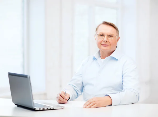 Old man in eyeglasses filling a form at home — Stock Photo, Image