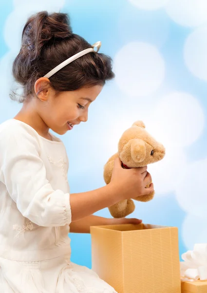 Щаслива дівчинка з подарунковою коробкою і плюшевим ведмедем — стокове фото