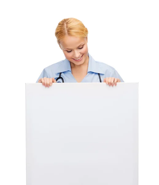 Smiling female doctor or nurse with blank board — Stock Photo, Image