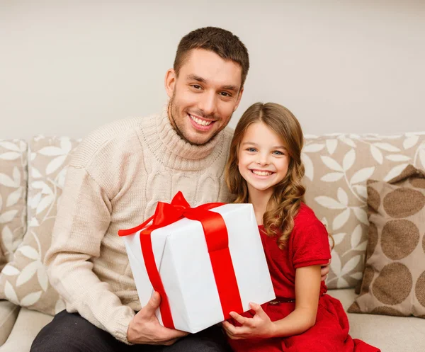 Leende far och dotter håller presentförpackning Stockbild
