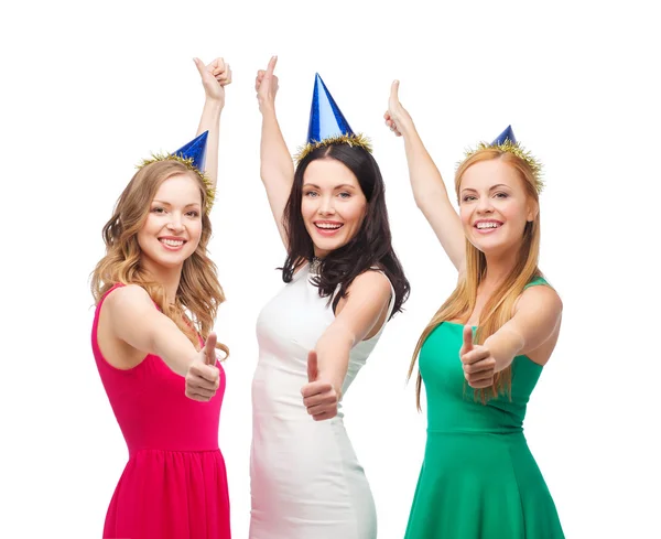 Три жінки носять капелюхи і показують великі пальці вгору Ліцензійні Стокові Зображення