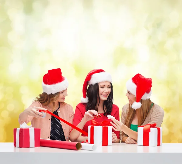 Santa yardımcı şapka hediye kutuları gülümseyen kadın — Stok fotoğraf