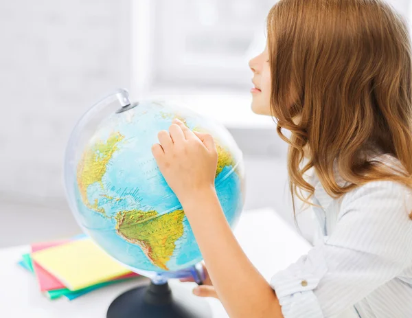 Neugierige Schülerin mit Globus in der Schule — Stockfoto