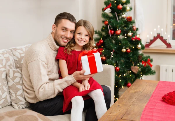 Leende far och dotter håller presentförpackning — Stockfoto