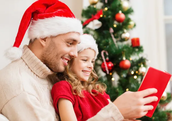 Sonriente padre e hija leyendo libro — Foto de Stock