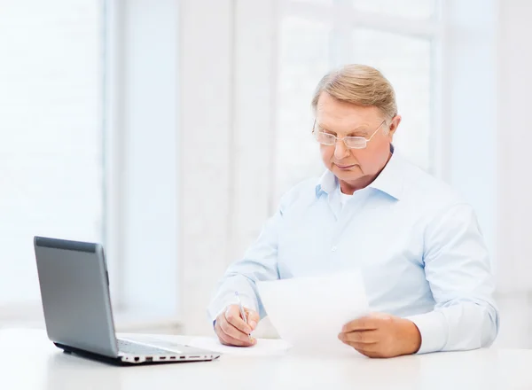 Old man in eyeglasses filling a form at home — Stock Photo, Image