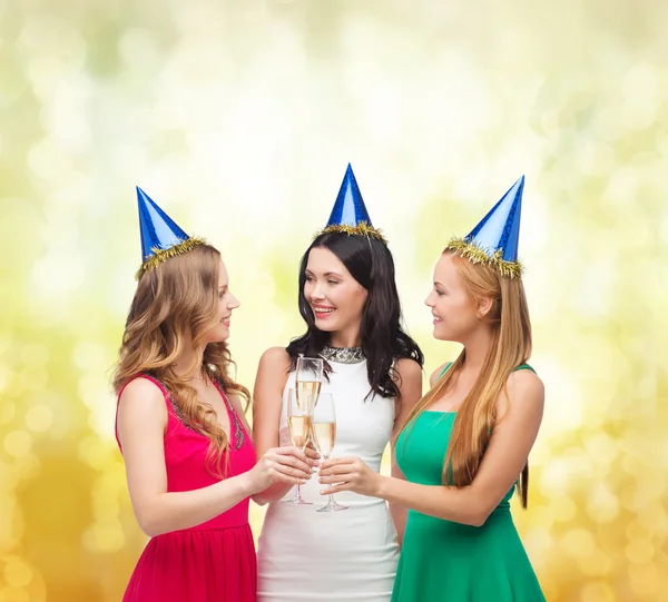 Three women wearing hats with champagne glasses Stock Picture