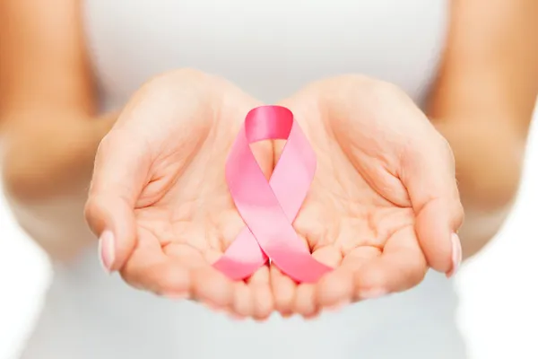 手ピンク乳がんの意識リボン ストック画像