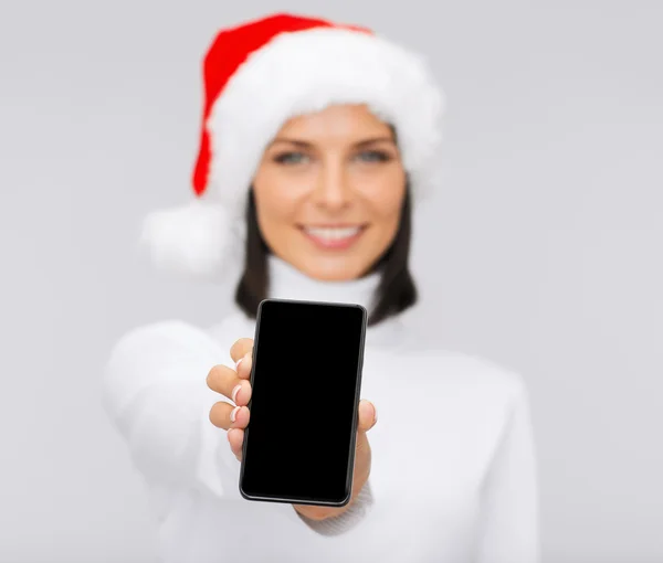 Lachende vrouw in helper kerstmuts met smartphone — Stockfoto