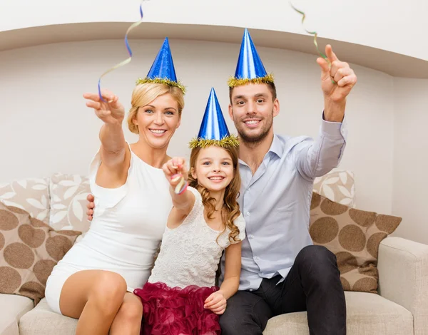 Smiling family in blue hats with cake — Stock Photo, Image