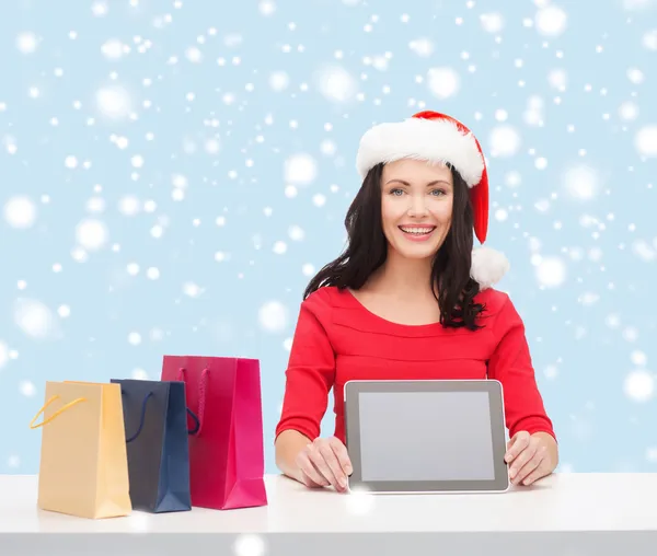 Mulher em santa chapéu auxiliar com tablet pc — Fotografia de Stock