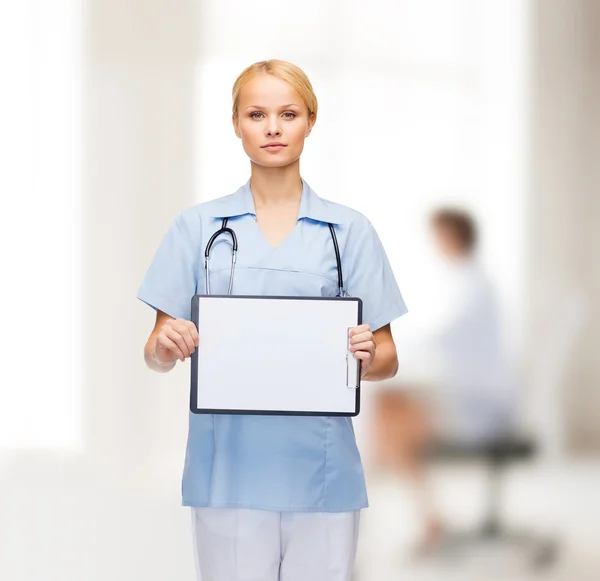 Médica ou enfermeira sorridente com prancheta — Fotografia de Stock