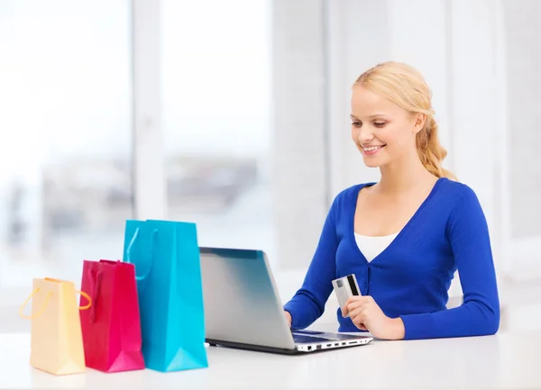 Mujer con laptop, bolsas de compras y tarjeta de crédito —  Fotos de Stock