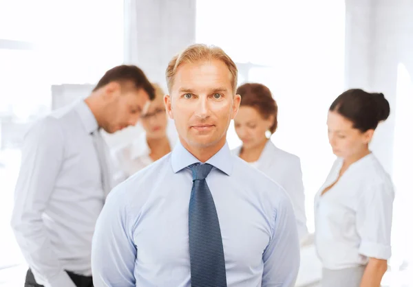 Affärsman i kontor med gruppen på baksidan — Stockfoto
