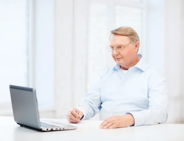 Old man in eyeglasses filling a form at home — Stock Photo, Image