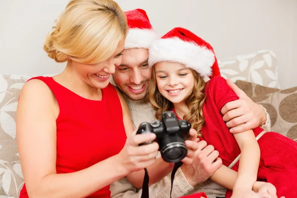 Familie in santa helper hoeden kijken naar pictires — Stockfoto