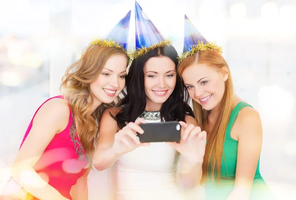 Three smiling women in hats having fun with camera Royalty Free Stock Photos