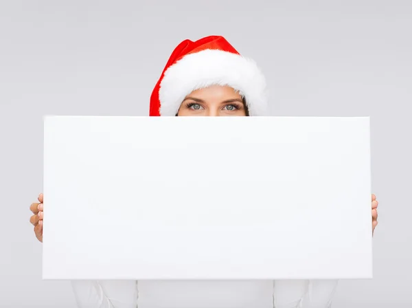 Nő a santa kalap segítő üres fehér tábla — Stock Fotó