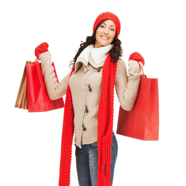 買い物袋で暖か着るべき服の女性の笑みを浮かべてください。 — ストック写真
