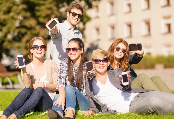 Studenti che mostrano smartphone — Foto Stock