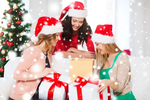 Donne in cappelli Babbo Natale aiutante con molte scatole regalo — Foto Stock