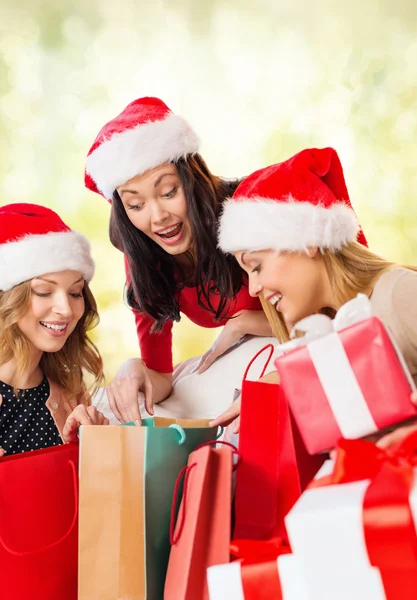 Mulheres em Santa helper chapéus com sacos de compras — Fotografia de Stock