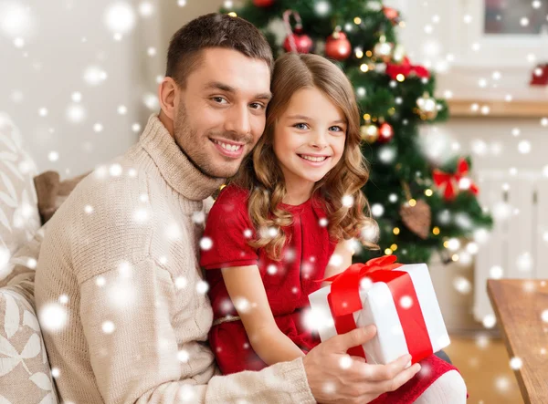 Leende far och dotter håller presentförpackning — Stockfoto