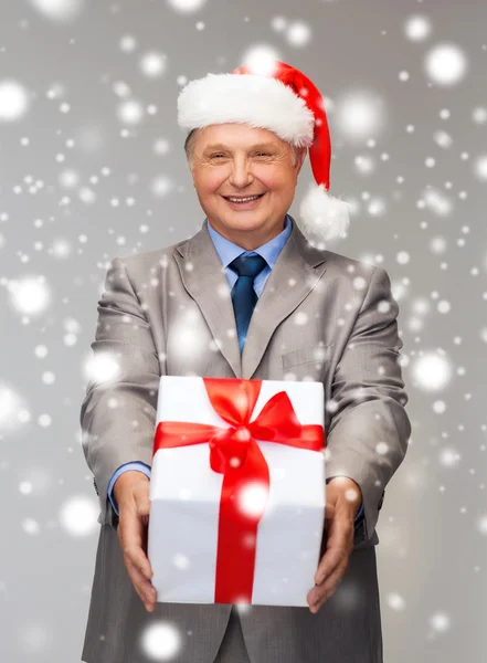 Smiling man in suit and santa helper hat with gift — Stock Photo, Image